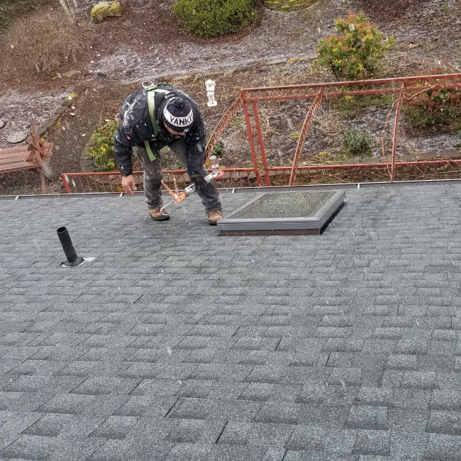 contractor inspecting asphalt roofing